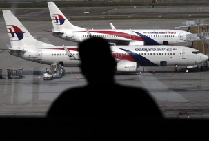 Ein Passagier blickt am Kuala Lumpur International Airport auf Flugzeuge der Malaysia Airlines., © dpa/Ahmad Yusni