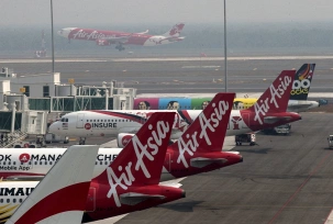 Airbus-Flugzeuge der Air Asia auf dem Kuala Lumpur International Airport in Sepang. 50 Millionen Euro soll Airbus den Managern der Airline für Großbestellungen gezahlt haben., © dpa/Ahmad Yusni/EPA