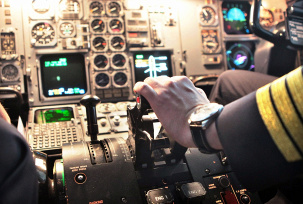 Ein Pilot hat seine Hand am Schubhebel., © dpa/Jan Woitas