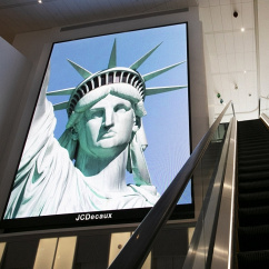 New York: Ein elektronisches Bildschirmbild der Freiheitsstatue begrüßt ankommende Reisende auf einer Rolltreppe im Terminal B des Flughafens LaGuardia., © dpa/Mark Lennihan/AP