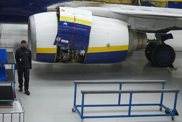 Ein Arbeiter führt Wartungsarbeiten am Triebwerk einer Ryanair-Maschine im Hangar der Airline in Sevilla durch., © dpa/Joaquin Corchero