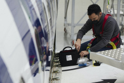 Ein Arbeiter führt an einer Ryanair-Maschine im Hangar der Airline in Sevilla Wartungsarbeiten durch., © dpa/Joaquin Corchero