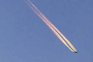 Ein Flugzeug fliegt am frühen Morgen am blauen Himmel und zieht einen Kondensstreifen hinter sich her., © DPA/Thomas Banneyer