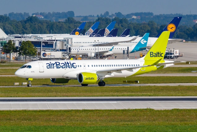 Airbus A220 von Air Baltic am Flughafen München vor Flugzeugen der Lufthansa Group., © AirTeamImages.com/Markus Mainka
