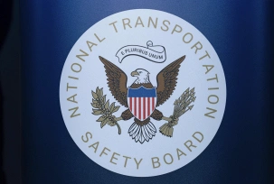 Das Siegel der Nationalen Verkehrssicherheitsbehörde, des National Transportation Safety Board, hängt bei einer Pressekonferenz am Ronald Reagan Washington National Airport, in Arlington., © DPA/Jose Luis Magana/AP