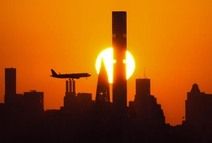 USA, New York: Die Sonne geht hinter der Skyline von Manhattan unter, als ein Flugzeug in New York landet., © DPA/Frank Franklin II/AP