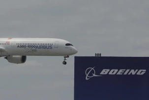 Ein Airbus A350-1000 fliegt bei einer Flugvorführung auf der Luftfahrtmesse Salon du Bourget nördlich von Paris an einem Logo von Boeing vorbei., © DPA/Michel Euler