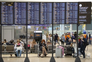 Passagiere sitzen auf dem internationalen Flughafen Scheremetjewo unter einer Fluginformationstafel., © DPA/Alexander Zemlianichenko Jr/XinHua