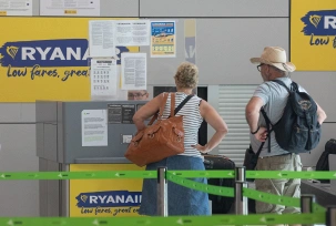 Passagiere stehen an den Schaltern von Ryanair bei der Gepäckaufgabe am Flughafen., © DPA/Clara Margais