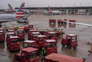 Ein Arbeiter steht auf dem Rollfeld inmitten von Flugzeugen der American Airlines am Chicago O'Hare International Airport., © DPA/Adam Gray