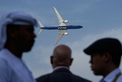 Männer betrachten eine Boeing 777X auf der Dubai Air Show., © DPA/Fatima Shbair
