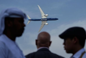 Männer betrachten eine Boeing 777X auf der Dubai Air Show., © DPA/Fatima Shbair