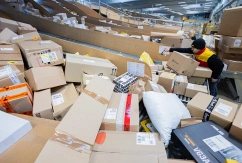 Ein Paketzusteller sortiert und räumt in einer Zustellbasis von Deutsche Post DHL-Pakete in ein Zustellfahrzeug., © DPA/Rolf Vennenbernd