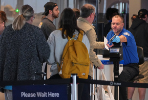 Ein Mitarbeiter der TSA (Transportation Security Administration) gibt einem Passagier an der Sicherheitskontrolle im internationalen Flughafen seinen Reisepass zurück., © DPA/Gene J. Puskar