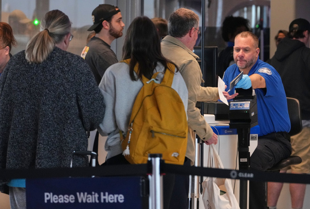 Ein Mitarbeiter der TSA (Transportation Security Administration) gibt einem Passagier an der Sicherheitskontrolle im internationalen Flughafen seinen Reisepass zurück., © DPA/Gene J. Puskar