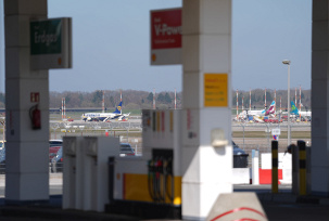 Flugzeuge sind hinter den Zapfsäulen einer Tankstelle am Flughafen Hamburg Airport zu sehen., © DPA/Marcus Brandt