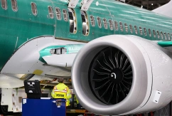 Ein Arbeiter steht neben einem Triebwerk einer Boeing 737 Max., © DPA/Lindsey Wasson