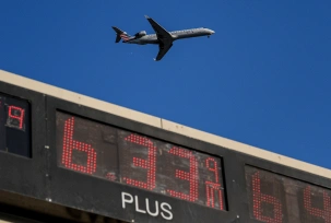 Ein American Eagle-Jet fliegt über einer Tankstelle in Inglewood, Kalifornien., © DPA/Jae C. Hong