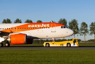 Ein elektrischer Taxibot-Schlepper zieht am Flughafen Amsterdam ein Easyjet-Flugzeug., © Flughafen Schipol
