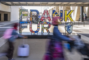 Reisende gehen an einem Frankfurt-Schriftzug am neuen Terminal 3 vorbei., © DPA/Andreas Arnold