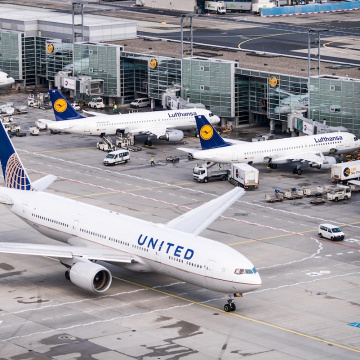 Eine Boeing 777 von United rollt am Flughafen Frankfurt, dahinter Flugzeuge der Lufthansa am Gate., © AirTeamImages.com/Felix Gottwald