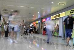 Menschen gehen am Flughafen an Mietwagen-Firmen vorbei., © DPA/Clara Margais