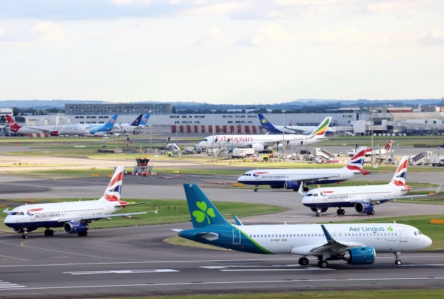Ein Airbus A320 startet im Vordergrund am Flughafen London-Heathrow, im Hintergrund mehrere Airbus-Jets von British Airways., © AirTeamImages.com/Derek Pedley