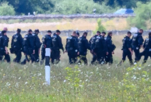 Einsatzkräfte der Polizei gehen abseits der Start-und-Lande-Bahn Nord des Flughafens Leipzig/Halle durch das Gelände., © DPA/Hendrik Schmidt