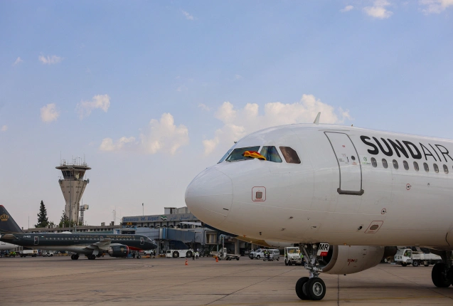 Der Kapitän ersten Sundair-Flugs nach Syrien schwenkt die deutsche Fahne am internationalen Flughafen von Damaskus., © DPA/Mohammed al-Rifai