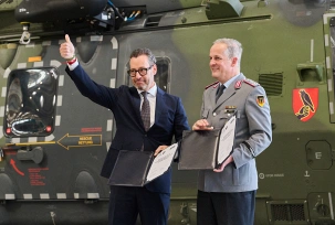 Jordi Boto, Geschäftsführer Elbe Flugzeugwerke (EFW, l), und Oberst i.G. Frederik Holz, stehen bei einem Pressetermin zur Unterzeichnung des Vertrages zur Instandhaltung von NH90-Hubschraubern zwischen Bundeswehr und der EFW vor einem solchen Helikopter., © DPA/Robert Michael